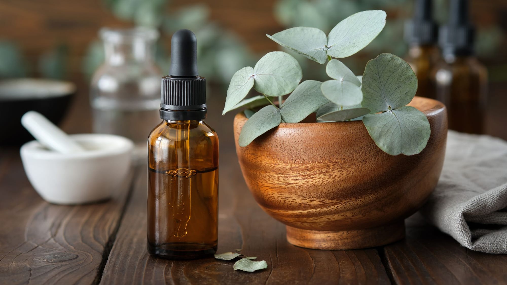 a small bottle of herbal oil and herb next to it