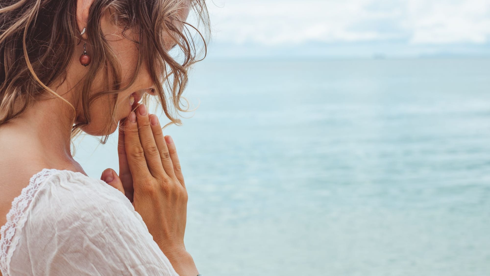 A woman praying by the sea-How To Cast A Circle Of Protection-Sage Sistas