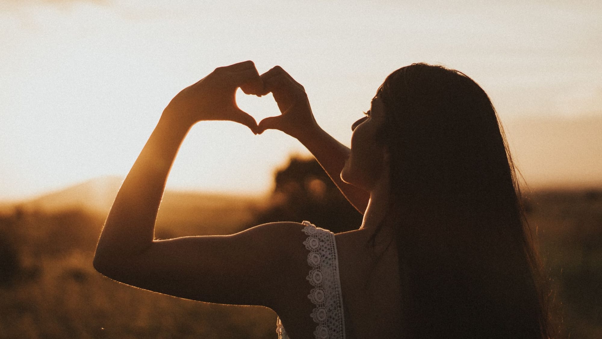 girl doing heart shape with fingers - German New Medicine Heart - Sage Sistas