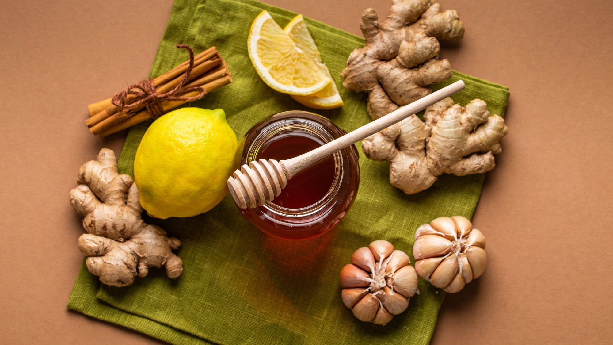 Some cinnamon, lemon, honey, ginger, and garlic placed on a green kitchen towel - German New Medicine Pancreas - Sage Sistas