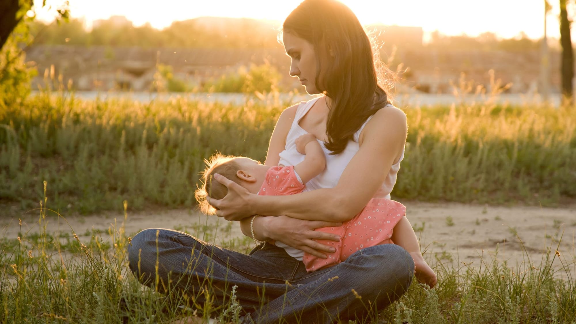 woman breast feeding her baby in nature - German New Medicine Female Breast - Sage Sistas